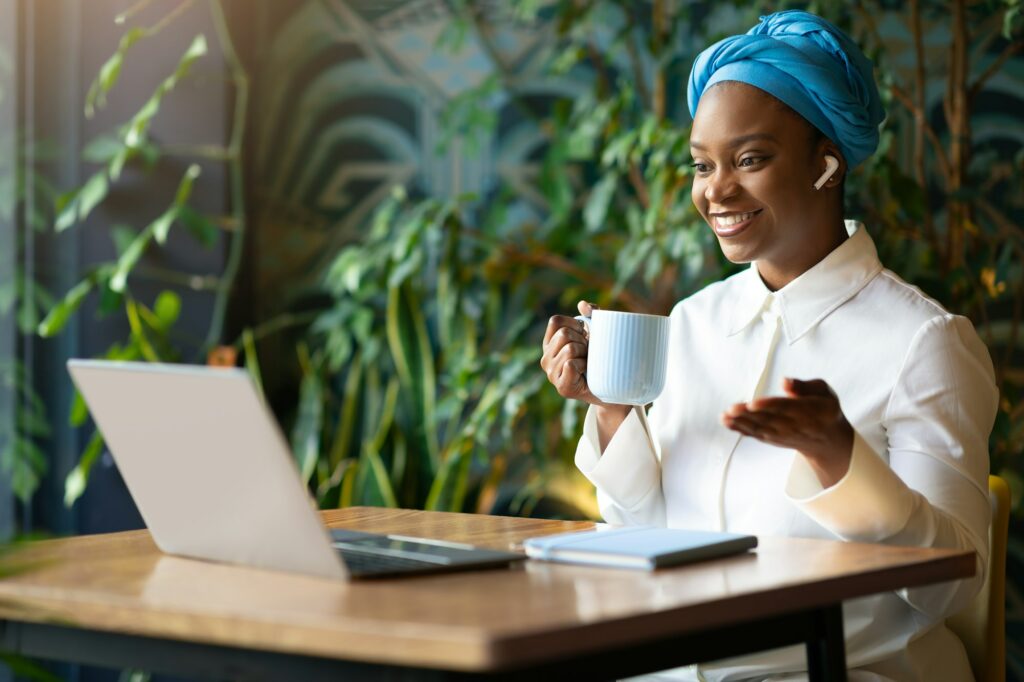 Positive black woman have online meeting, working at cafe